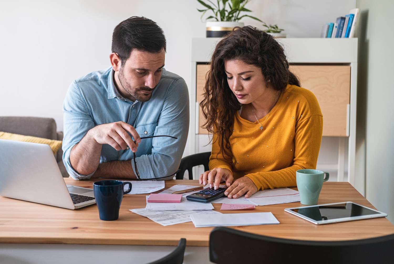 A couple reviews paperwork at a desk.