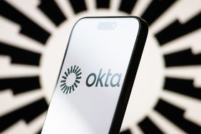 The logo of Okta is displayed on a smartphone screen, with the company's stylized black-and-white branding visible in the background