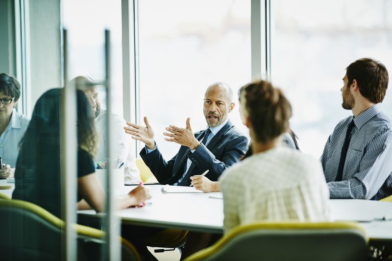 mature businessman leading a meeting in an office