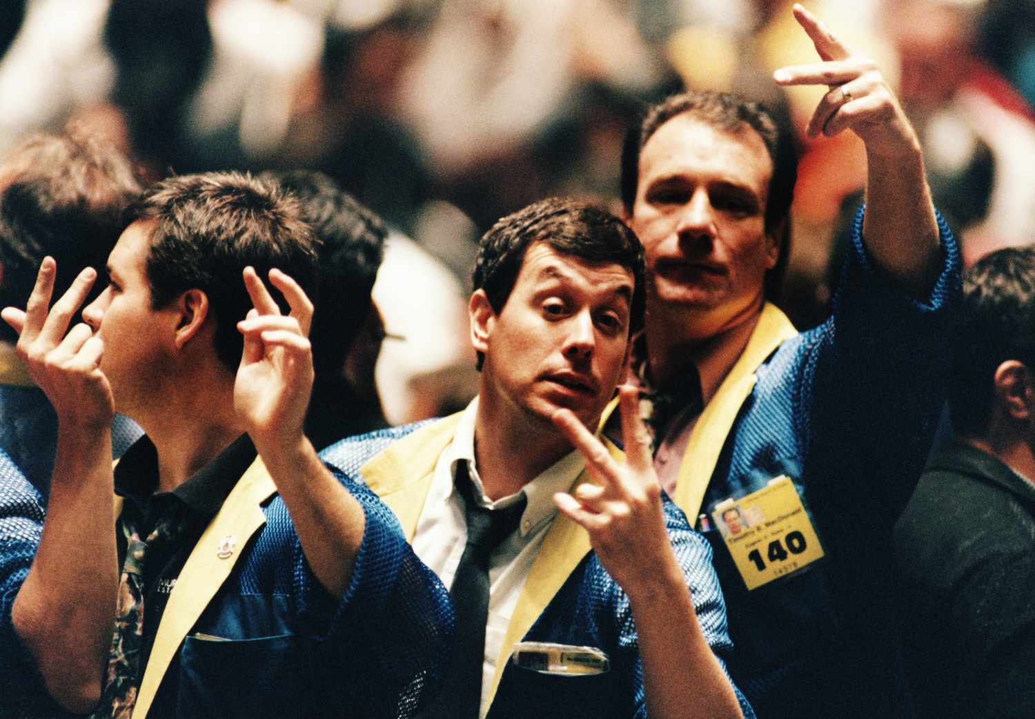 Traders on the floor of the Chicago Board of Trade gester to buy and sell securities.