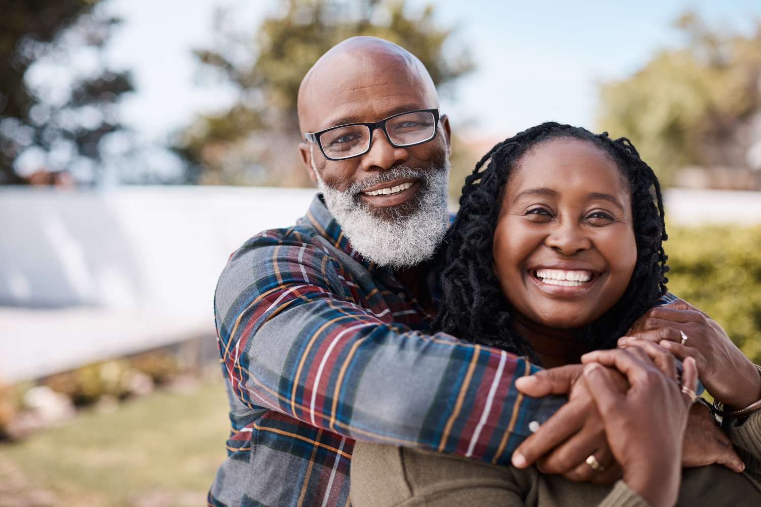 Elderly couple hugging each other outdoors