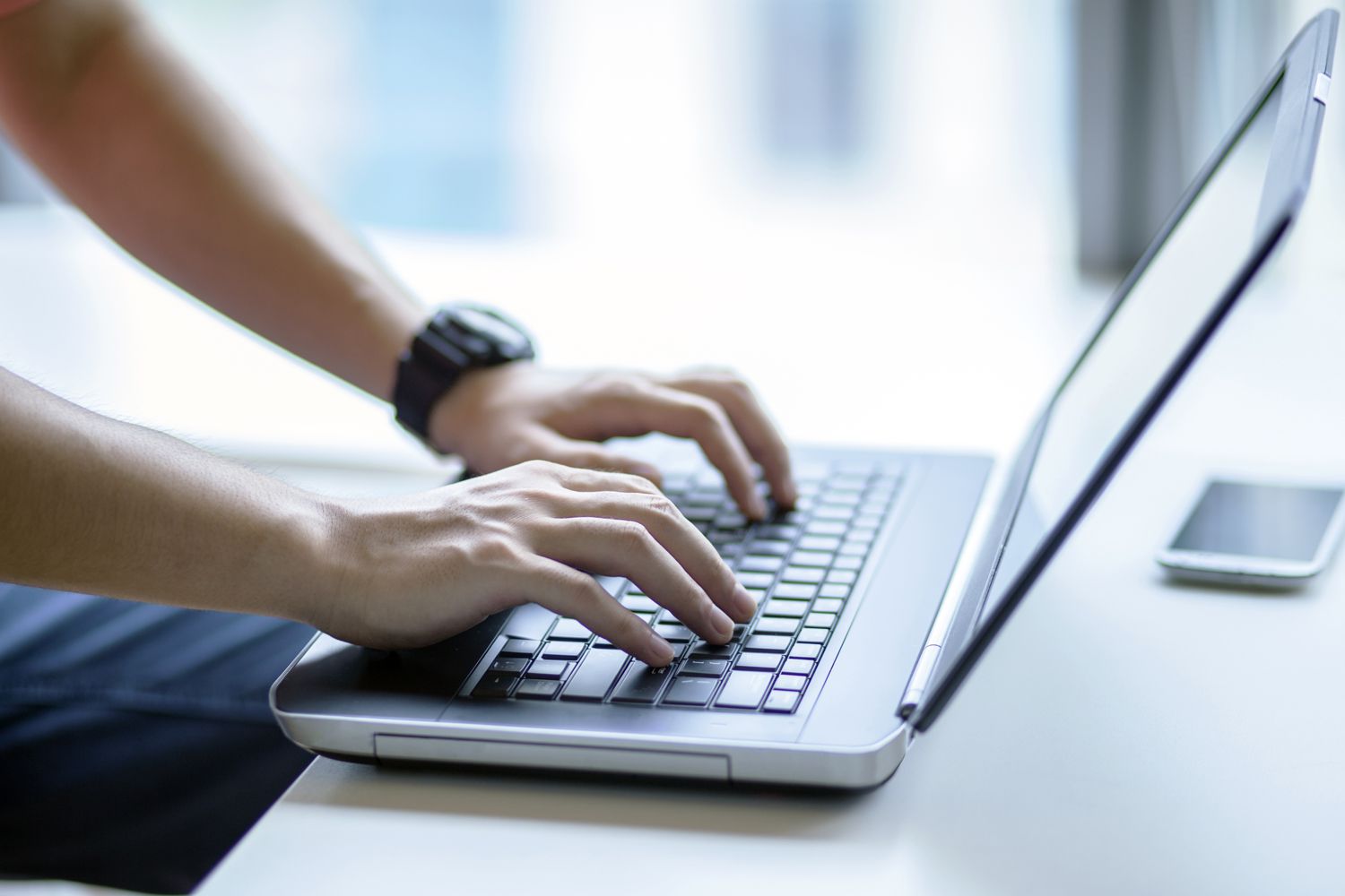 A person typing on a laptop.