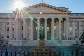 The sun flares over the headquarters of the U.S. Treasury on Jan. 3, 2024, in Washington, D.C. A statue of former Secretary of the Treasury Albert Gallatin sits in the courtyard.