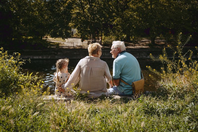 Older adults sitting with a child at a park
