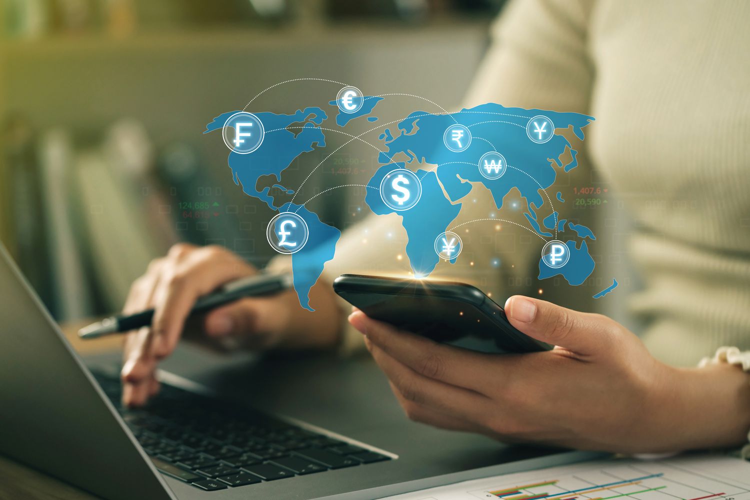 A accountant uses a computer and calculator to determine the exchange rate between two currencies.
