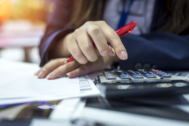 Person uses calculator while completing forms