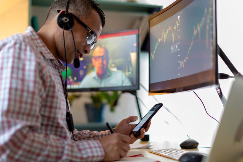 Two traders talking on video call to discuss the trading of spread option contracts.