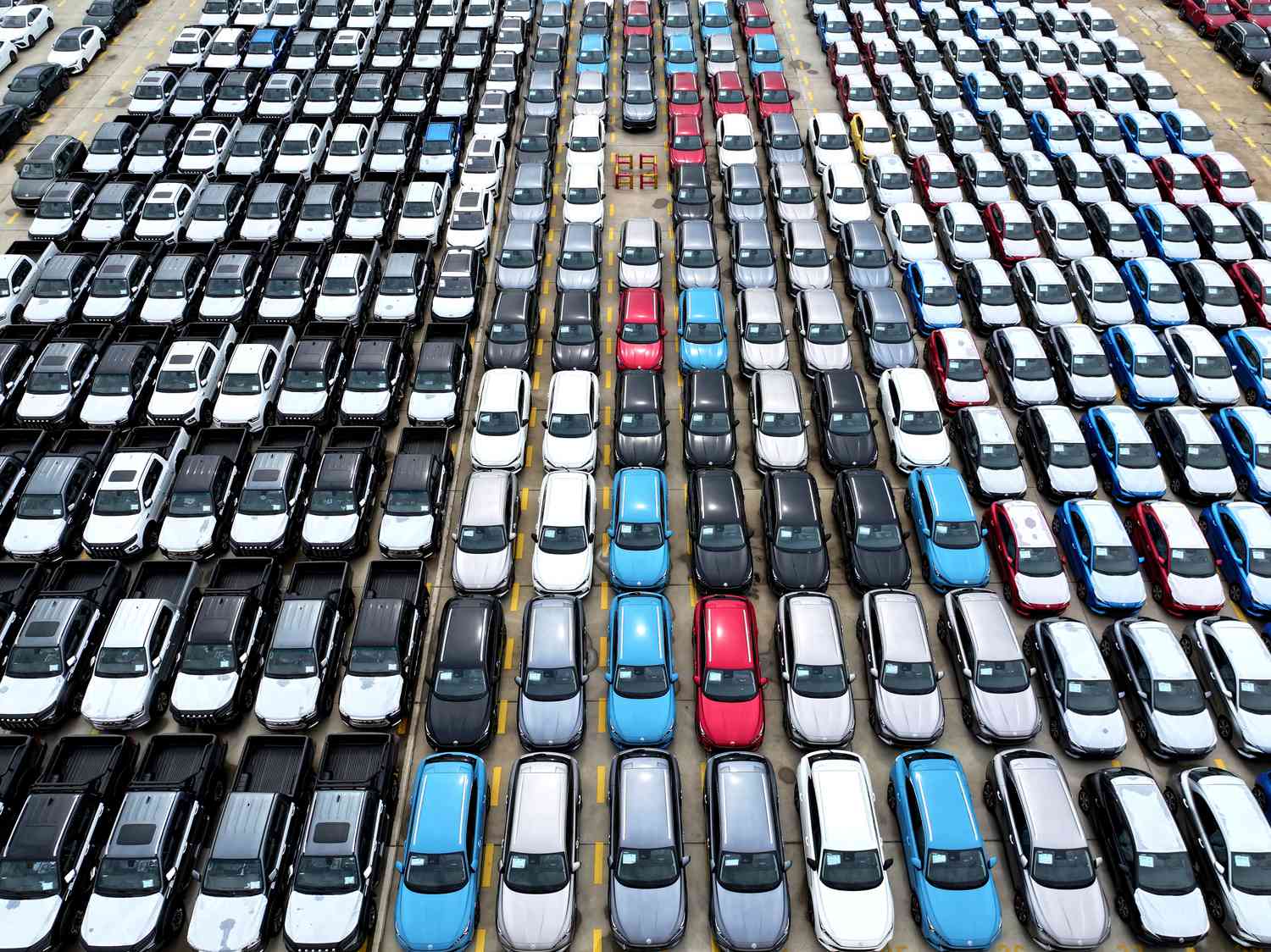 Dozens of vehicles in a range of colors are sitting on a dock, prepared to be exported from China.