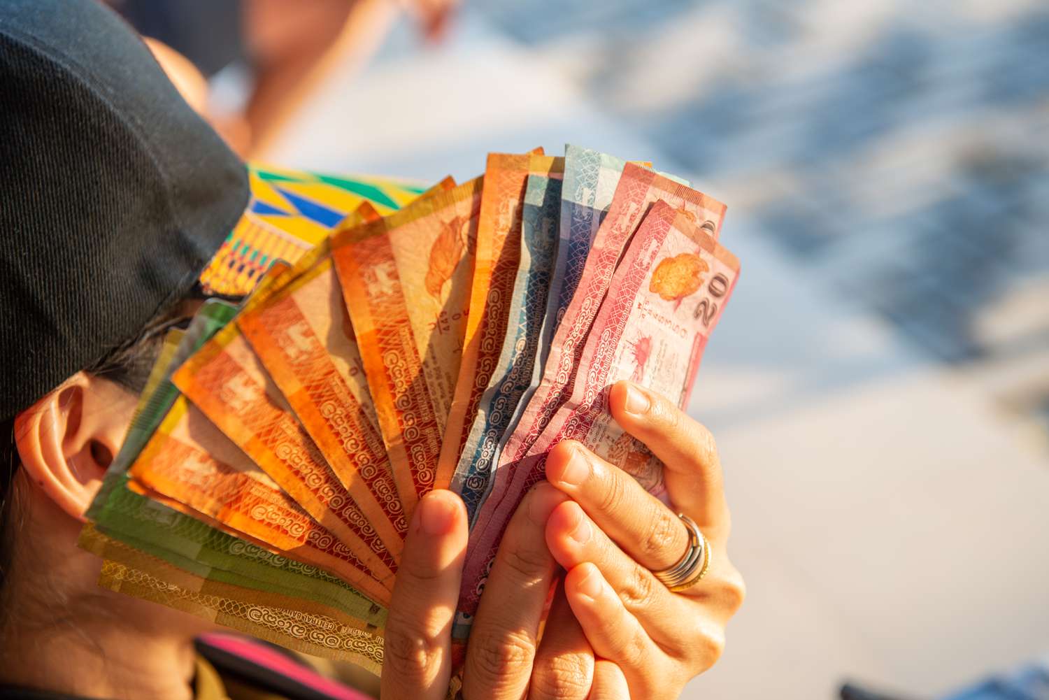 A person spreading bills of Sri Lankan rupee with both hands.
