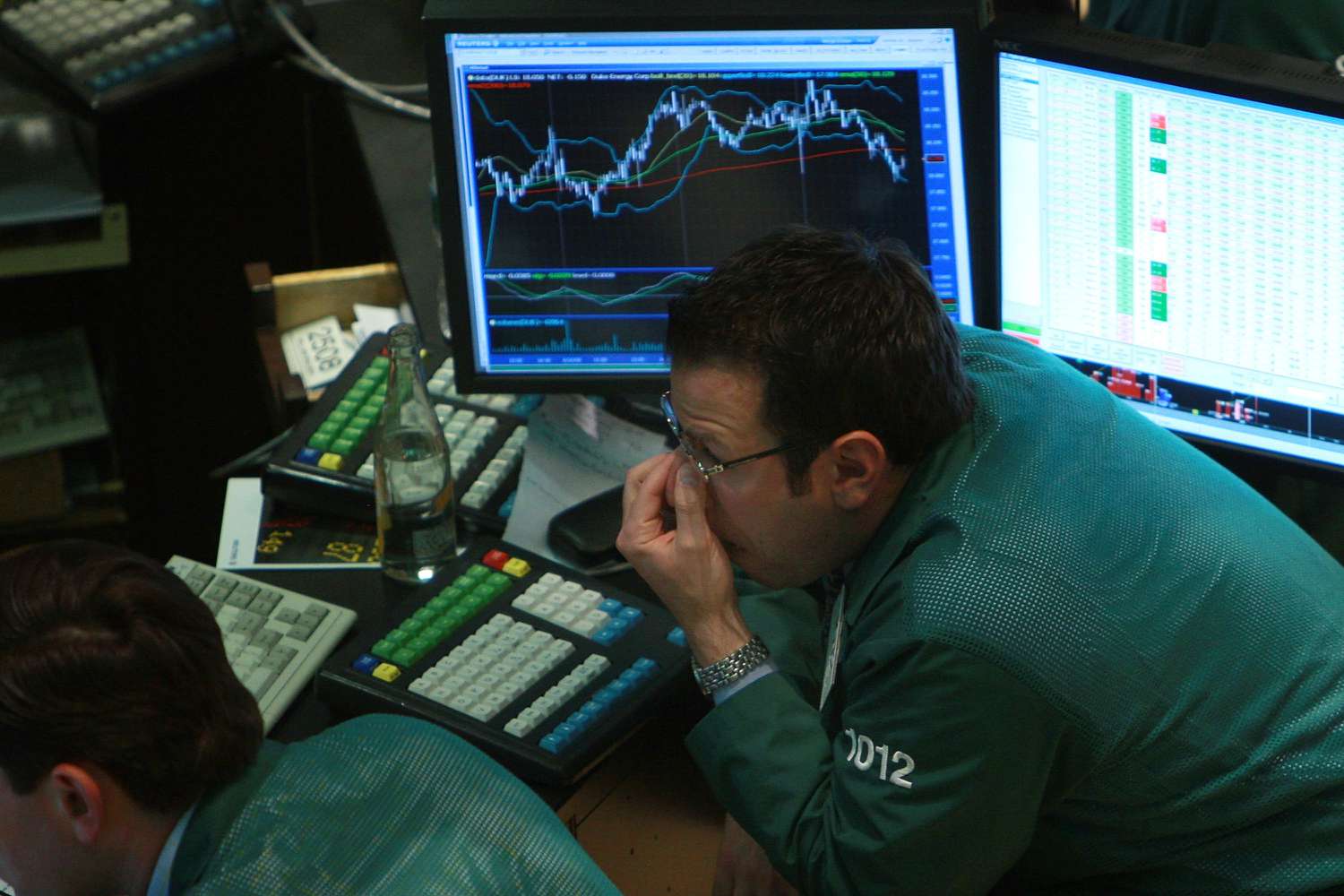 A stock trader working on the floor of the NYSE and analyzing currently over- and under-purchased securities.