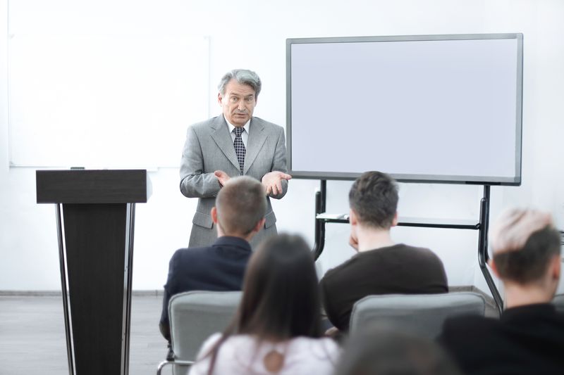 A professor presents a Economics Theory lecture about strong form efficiency to a group of students. 