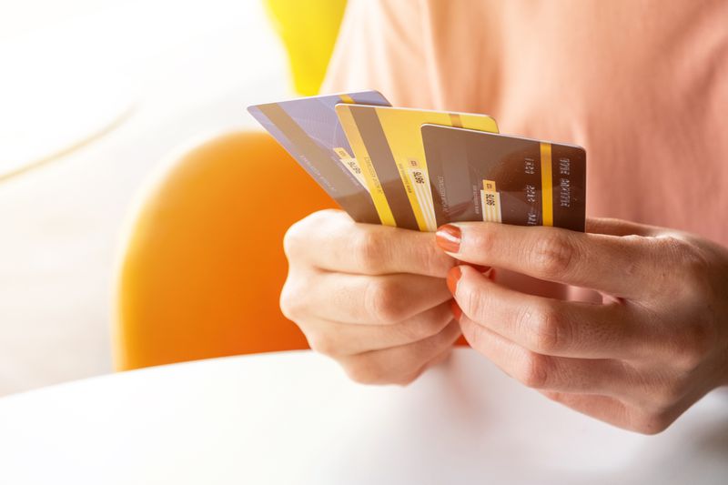 Cropped shot of female hands holding three credit cards