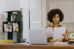 A woman reviews two documents.
