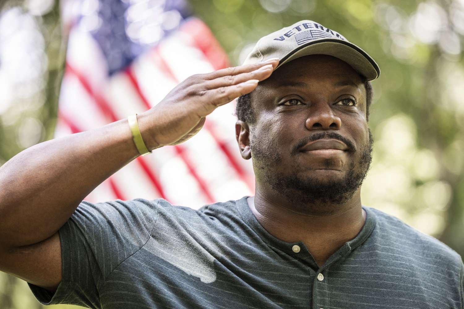 U.S. military veteran saluting with an American flag in the background