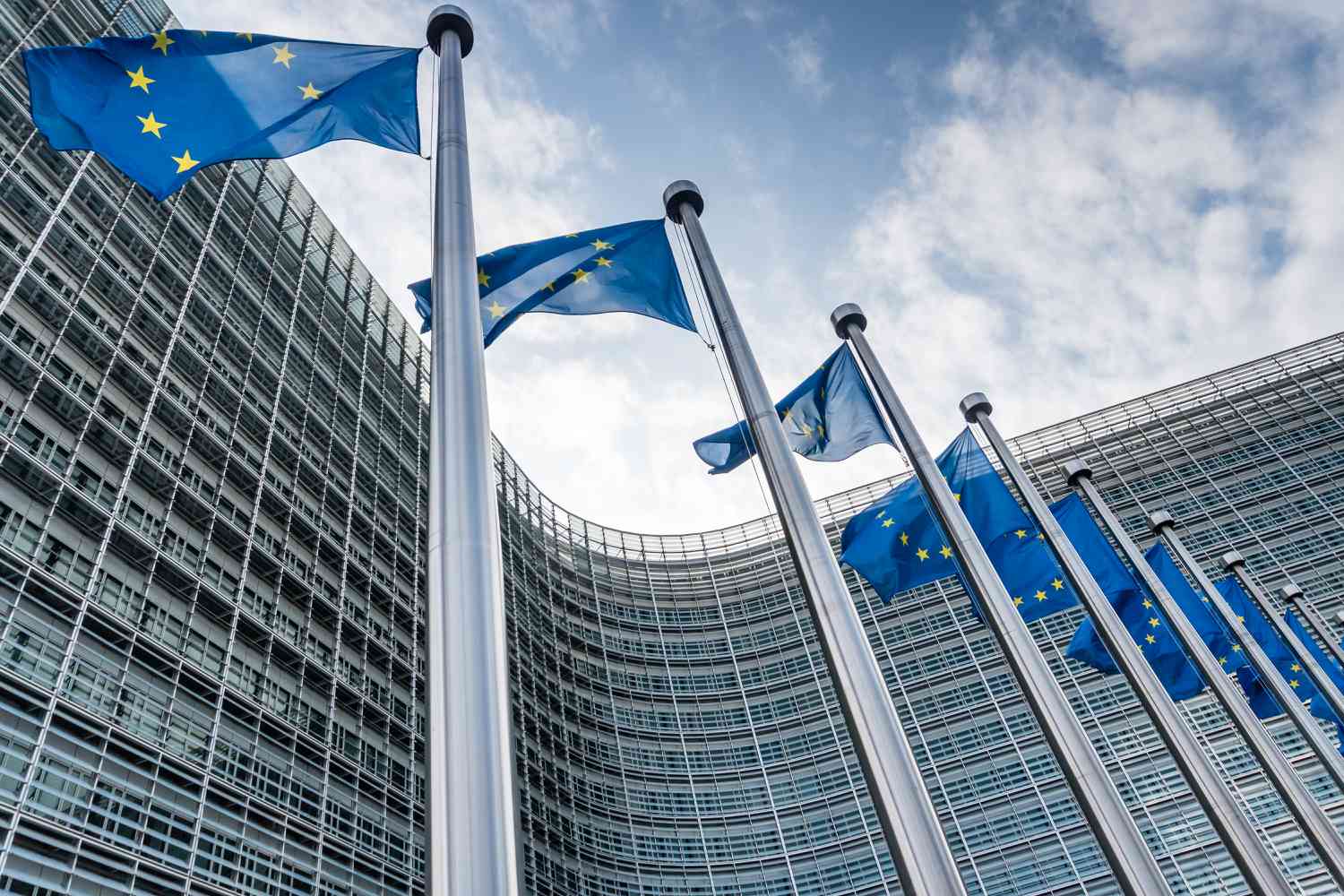 Several European Union flags wave outside the European Commission building in Belgium