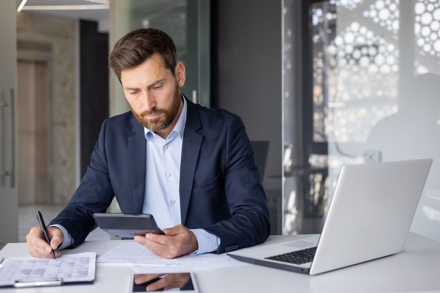 Mortgage lender calculating origination points from applicants and noting it down on paper.