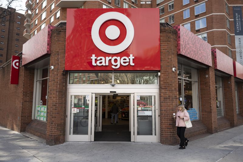 A person walks outside a Target store, with the company's red and white logo above the entrance.