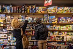Shoppers look at toys at a store. 