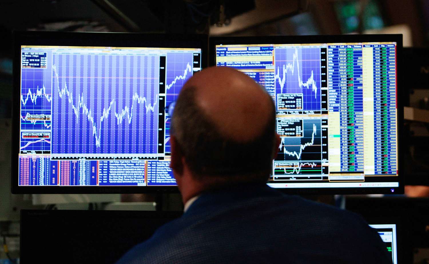 A financial professional loosk at his computer screen on the floor of the New York Stock Exchange at the end of the trading day