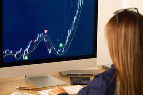 A trader sits in front of a computer monitor showing an explosive price increase of a stock that is not supportable or justified.