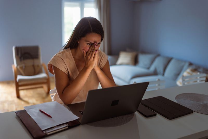 Worried woman in her home at a computer