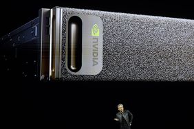 An Nvidia computer is displayed on a screen behind CEO Jensen Huang.