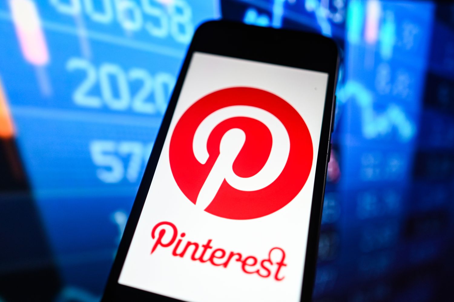Pinterest Logo on Smart Phone with Stock Market Percentages in Background