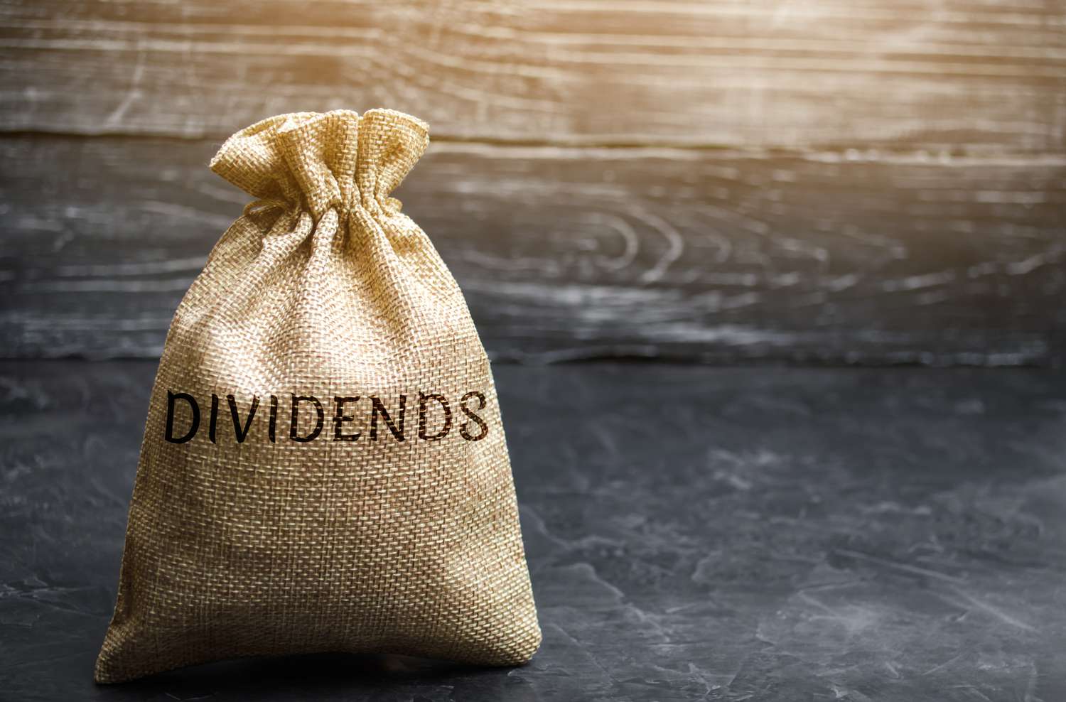Money bag with the word Dividends. A dividend is a payment made by a corporation to its shareholders as a distribution of profits.