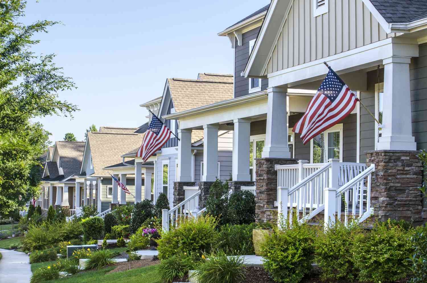 American Flags hang from the front porch of a row of new Victorian-style homes in North Carolina, United States.