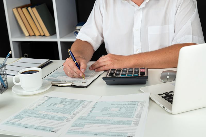 An accountant works at an office desk to complete tax documents for a business.