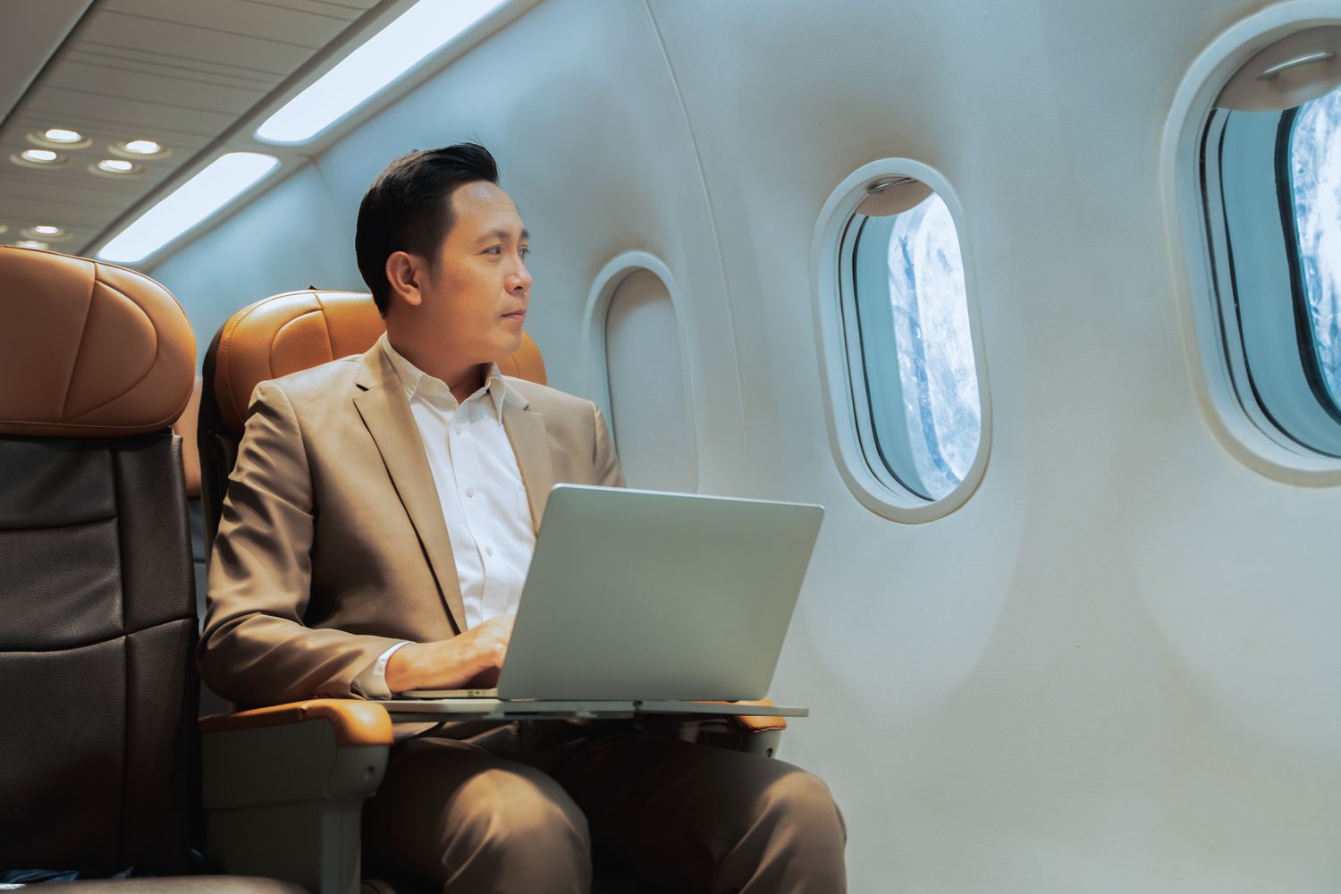 A business person on an airplane using a laptop