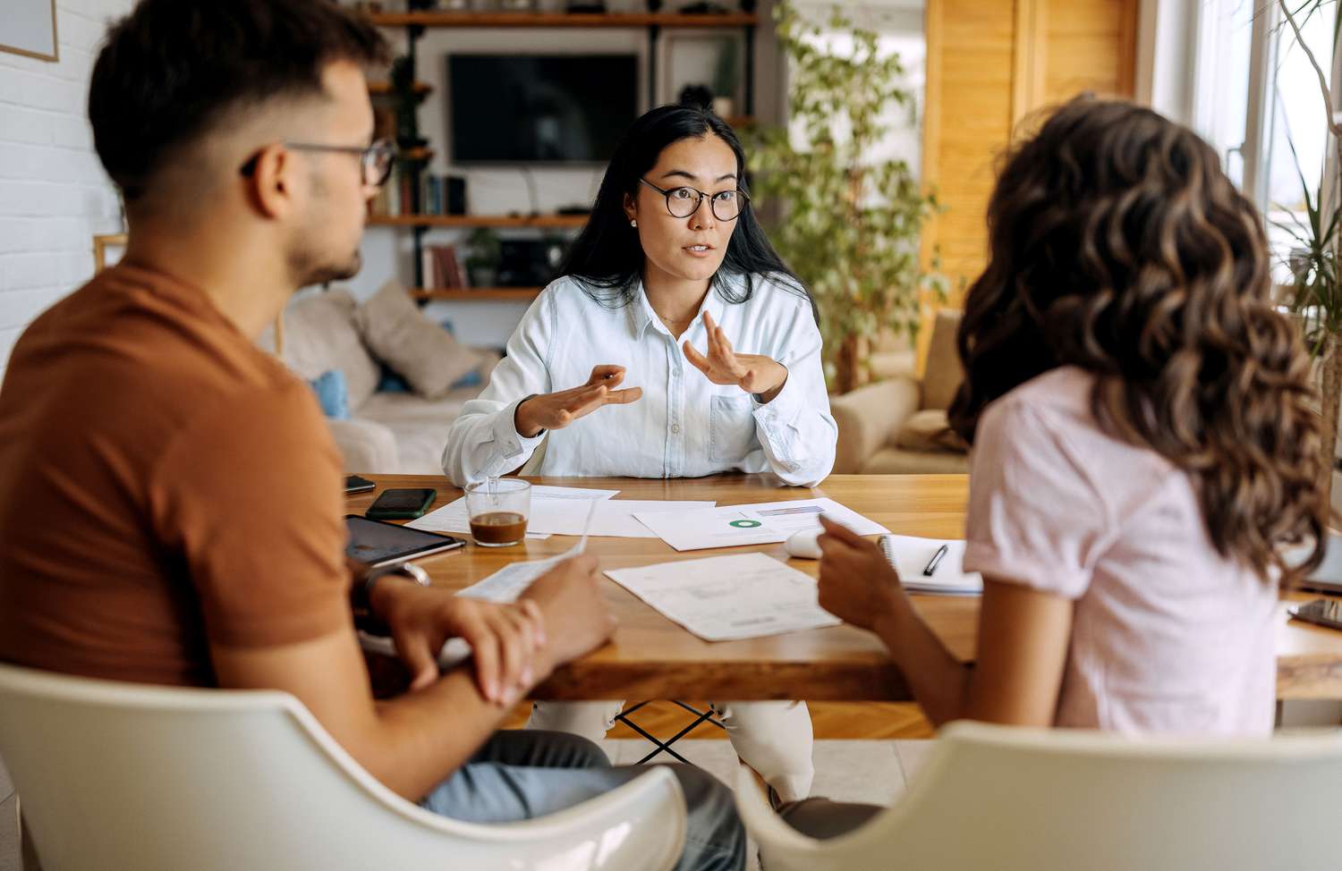 Couple meeting with a person, seated at a table with paperwork