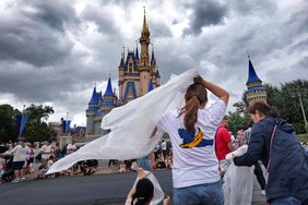 Guests at the Magic Kingdom break out ponchos at Cinderella Castle as bands of weather from Hurricane Helene move through Walt Disney World in Bay Lake, Florida, on Sept. 26, 2024