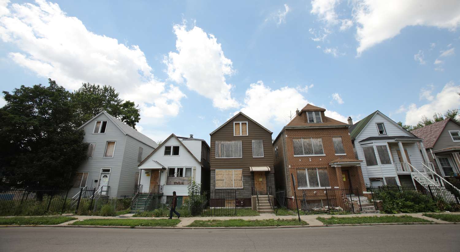 A man walks past five foreclosed homes in Chicago, July 21, 2010.