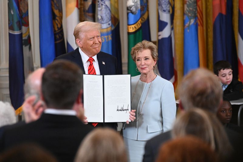U.S. President Donald Trump holding up a signed executive order poses with U.S. Education Secretary Linda McMahon at the White House on March 20, 2025 in Washington, DC.