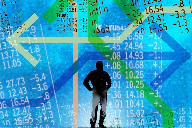 Man looking at confusing arrows and stock market data