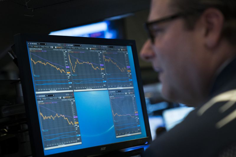 A trader checking the charts of several securities on a computer monitor.