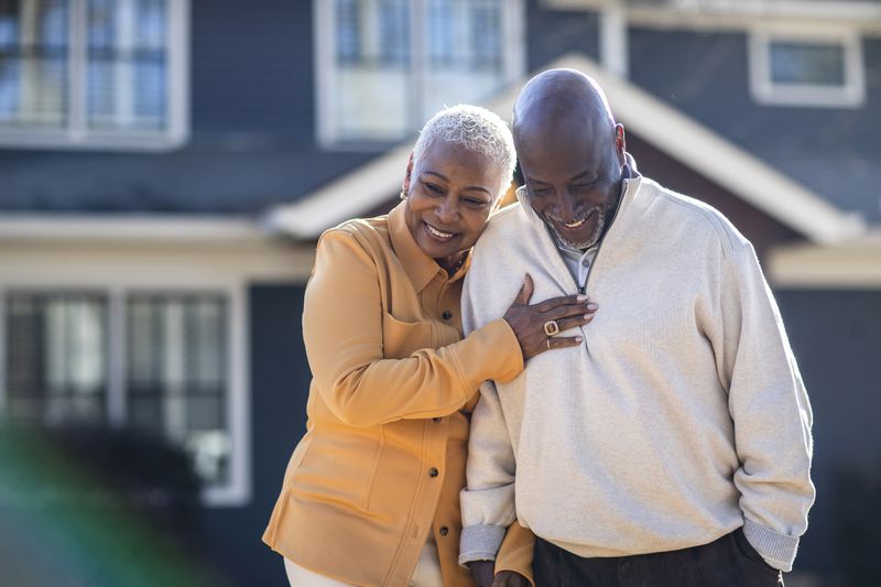 Senior couple couple walking in front of their home