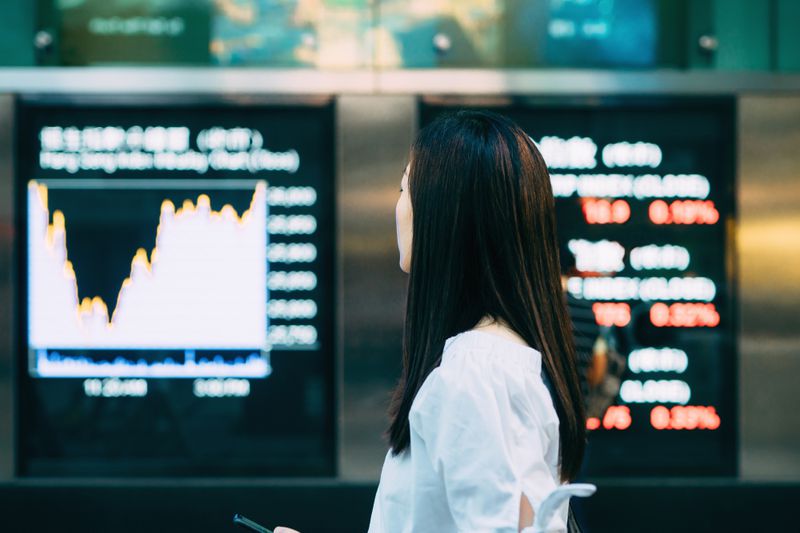 Retail investor looking at stock information displayed on digital screens to find penny stocks for investment.
