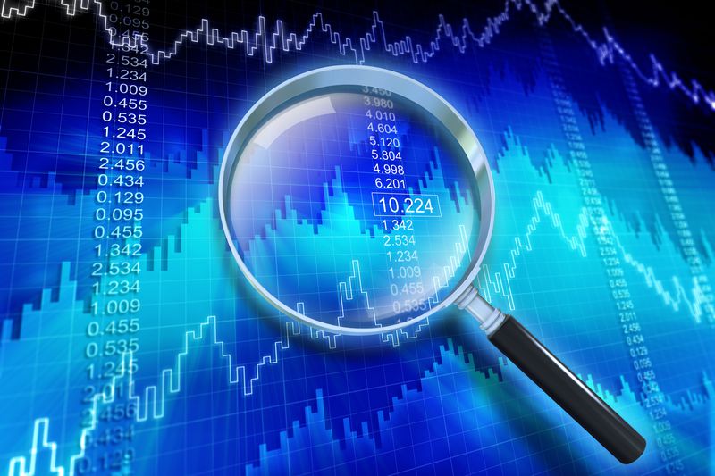 Financial data showing a rising trend with magnifying glass.