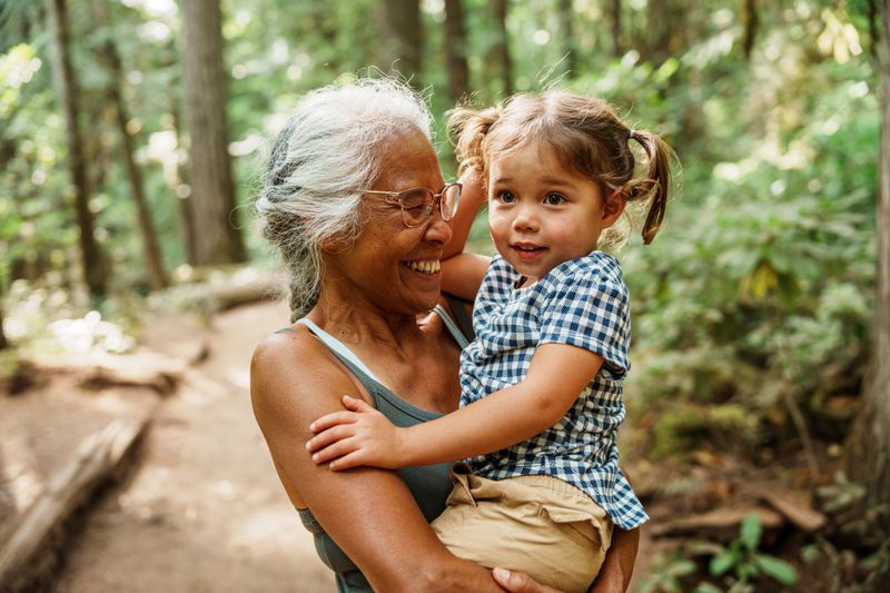 Older adult holds child outside