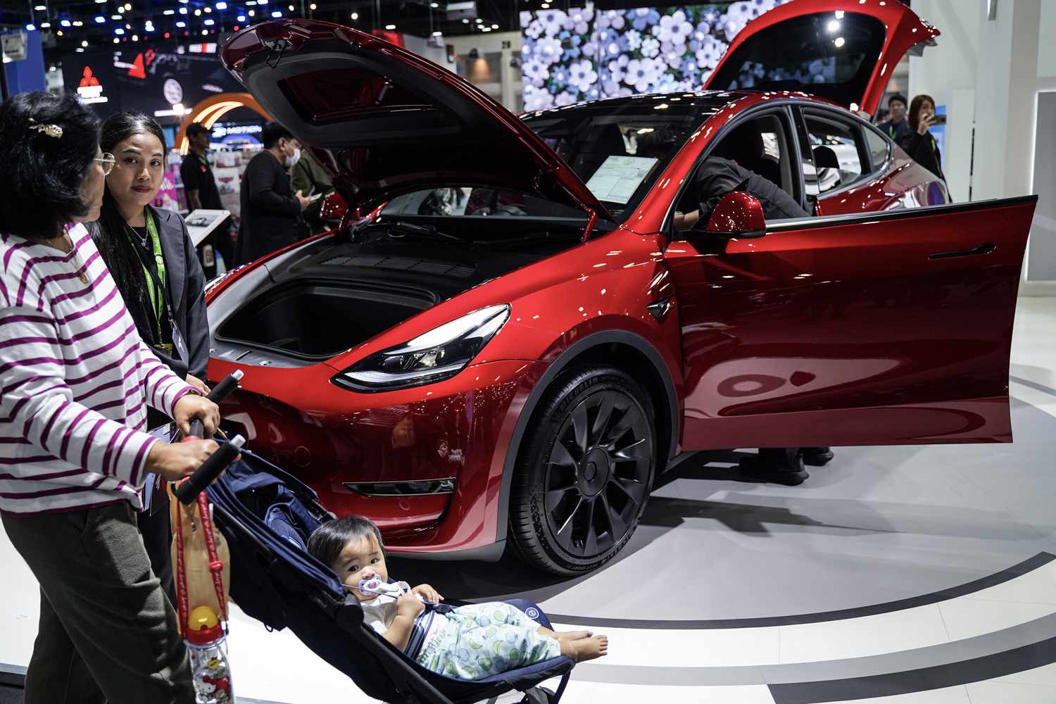 Visitors inspect a TESLA electric car displayed at the Thailand International Motor Expo 2024 at the IMPACT exhibition center in Bangkok, Thailand, on November 29, 2024. 