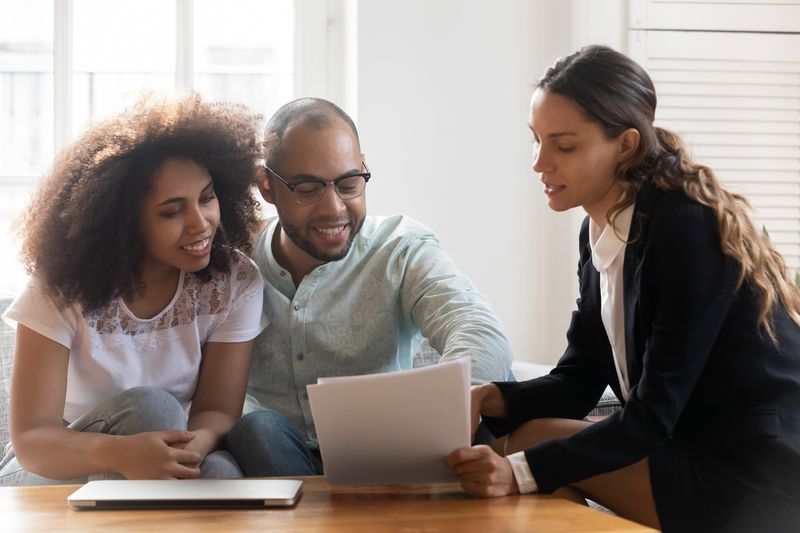 Couple discussing contract terms during meeting with mortgage lender
