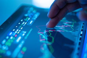 Cropped hand checking stock market data on a tablet