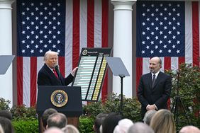 US President Donald Trump delivers remarks on reciprocal tariffs as US Secretary of Commerce Howard Lutnick holds a chart during an event in the Rose Garden entitled "Make America Wealthy Again" at the White House in Washington, DC, on April 2, 2025. 