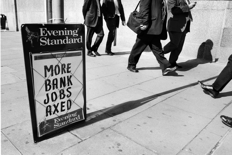 City commuters pass an Evening Standard newspaper billboard announcing 500 banking redundancies at the Canary Wharf headquarters of HSBC, November 2008.