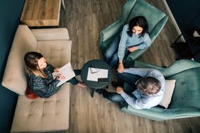 Hig angle ahot of three real estate investors sitting down and talking with each other.