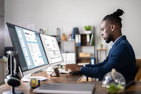 Man working on computer with invoices on the screen