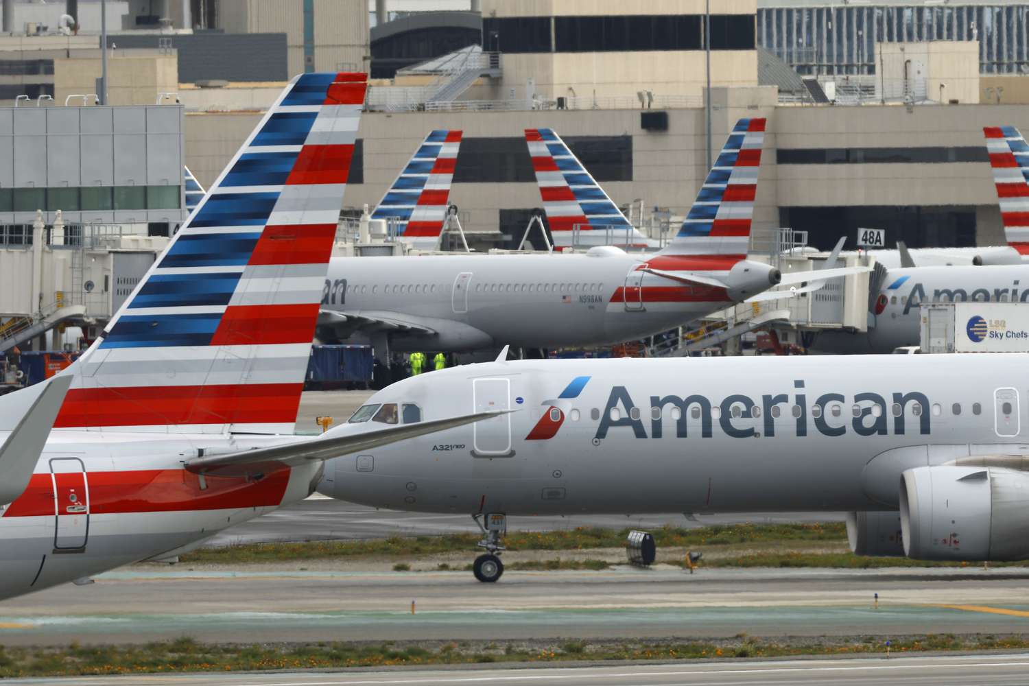Several American Airlines planes are seen at an airport.