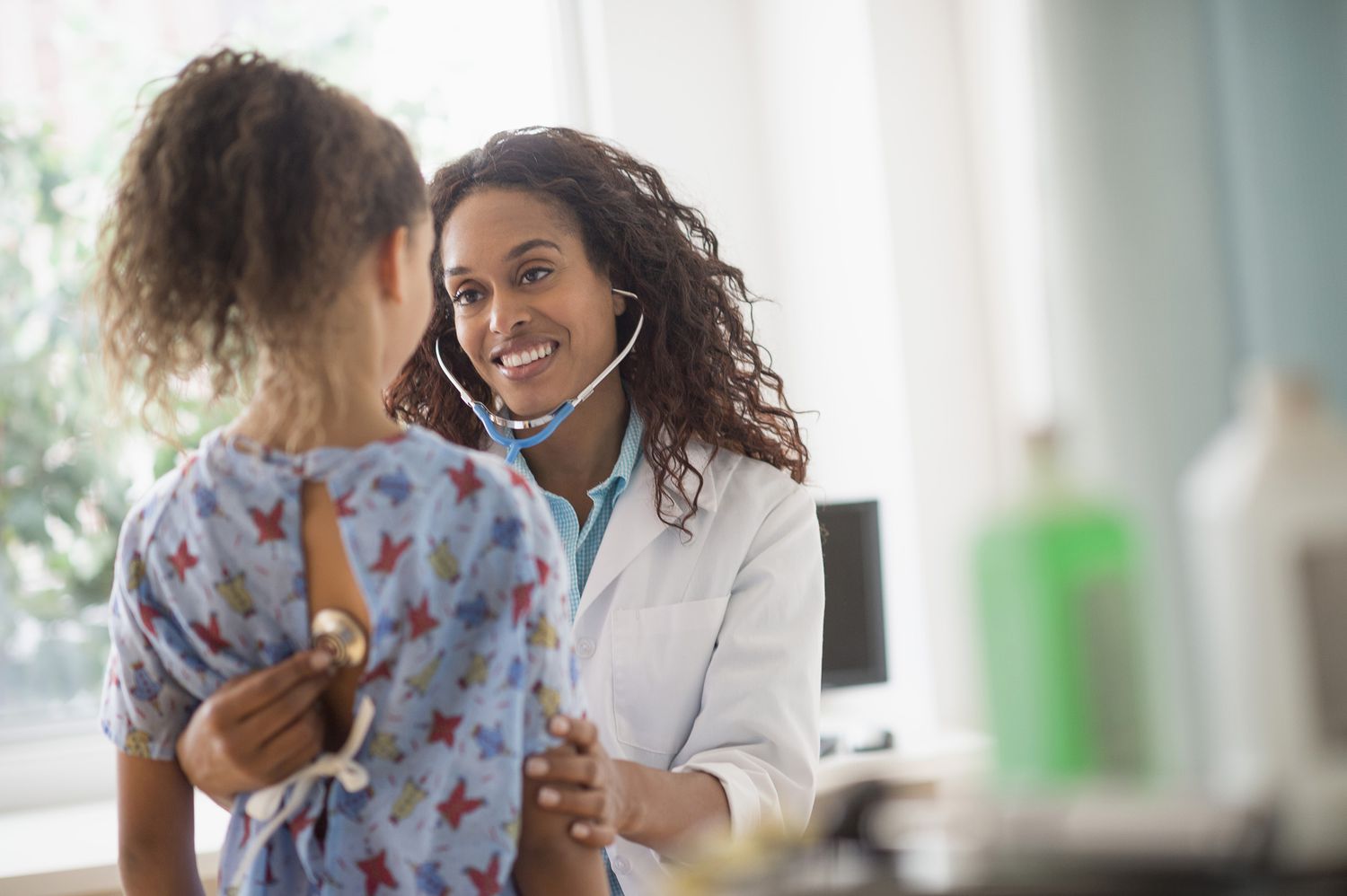 A doctor examines a child with a stethoscope. 